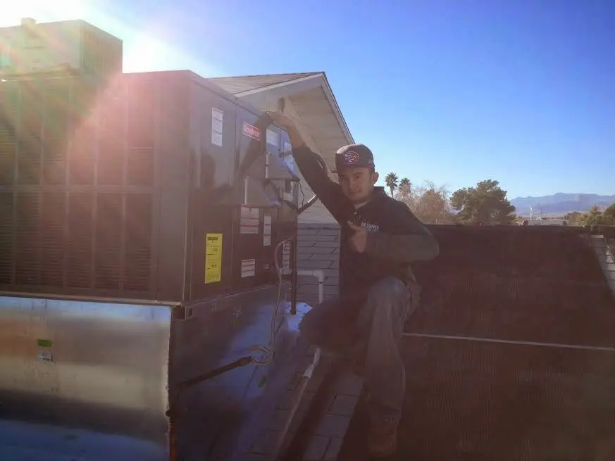 HVAC technician performing AC Tune-Up on a rooftop unit in Murray